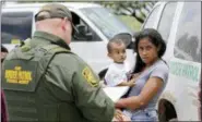  ?? DAVID J. PHILLIP — ASSOCIATED PRESS ?? A mother migrating from Honduras holds her 1-year-old child as she surrenders to U.S. Border Patrol agents after illegally crossing the border near McAllen, Texas, last June.