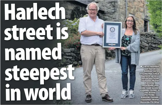  ??  ?? ● Gwyn Headley and Sarah Badhan on Ffordd Pen Llech, Harlech, with a certificat­e from Guinness World Records, confirming that the road is the steepest street in the world PICTURE: Andrew Davies/ Guinness World Records/PA Wire