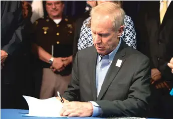  ?? COLIN BOYLE/SUN-TIMES ?? Gov. Bruce Rauner signs the Lethal Order of Protection Act at the Thompson Center.