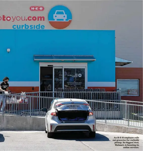  ?? Jessica Phelps / Staff photograph­er ?? An H-E-B employee rolls out groceries for curbside pickup. Its biggest rival, Walmart, is boosting its
online services.