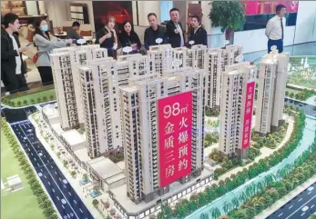  ?? LYU MING / CHINA NEWS SERVICE ?? Potential homebuyers look at a property model in Fuzhou, capital of East China’s Fujian province.