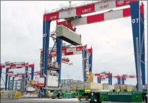  ?? BLOOMBERG/ TIM RUE ?? A container is loaded onto an automated- guided vehicle during the testing phase of the Long Beach Container Terminal in Middle Harbor at the Port of Long Beach, Calif., earlier this month.