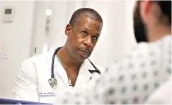  ?? Gus Chan/The Plain Dealer via AP ?? ■ Dr. Carl Allamby talks to a patient about his medical history in the emergency department at Cleveland Clinic Akron General Hospital on July 8 in Akron, Ohio.