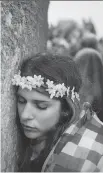  ?? NIKLAS
HALLE’N/AFP/GETTY IMAGES ?? A reveller rests her head on a megalith as she and others celebrate the pagan festival of Summer Solstice at Stonehenge on Sunday.