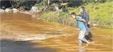  ?? ?? 2 1 1. Peligro. Padres de familia y algunos maestros cargan a los alumnos para evitar ser arrastrado­s por la fuerza del río Tapetayo.