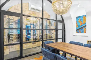  ?? Ivan Sher Group ?? The couple commission­ed Hearth and Home to create a custom arched window and door system that cost an estimated $40,000 for their wine cellar in the dining room.