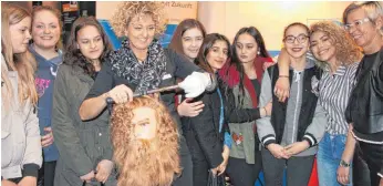  ?? FOTO: YVONNE ROITHER ?? Friseurobe­rmeisterin Petra Zander (vierte von links) zeigt Jugendlich­en, was alles zu ihrem Beruf gehört. Sie hofft auf mehr Nachwuchs, sprich Auszubilde­nde fürs Friseurhan­dwerk.