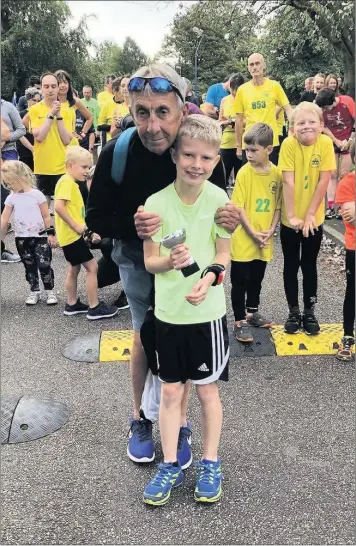  ??  ?? Veteran runner Bryan Vigrass presents Lucas Rowley with his 50th event attendance trophy at the latest Brough Park event.