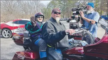  ?? (Special to NWA Democrat-Gazette/Alexus Underwood) ?? Evelyn Eales waves as she arrives to her takeoff location, the parking lot of St. Theodore Episcopal Church. She grinned and laughed while waiting for her ride to begin, saying phrases like, “this is wild” to the crowd.