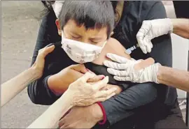  ?? Genaro Molina Los Angeles Times ?? A NURSE gives a 6-year-old boy a f lu shot in Los Angeles in October 2020. L.A. County’s latest positivity rate for flu was 25%, up from 13% last week.