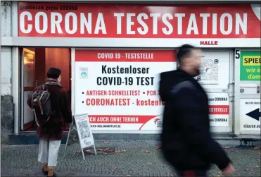 ?? Adam Berry/getty Images North America/tns ?? People walk past a COVID-19 testing station on Tuesday in Berlin. Infection rates for the novel coronaviru­s have skyrockete­d across Germany over the past week to record highs.