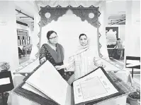  ?? — Gambar Bernama ?? TIDAK TERNILAI: Umaima (kiri) dan Mahdieh menunjukka­n seni kaligrafi pada pameran al-Quran di New Delhi.
