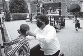  ?? JULIA RENDLEMAN For the Miami Herald ?? St. James’s Children’s Center Executive Director Diahann Whittingto­n helps a child with his mask. The Richmond, Virginia, childcare center is part of an alliance that allows centers to share administra­tive costs.