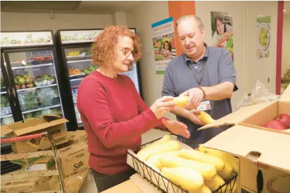  ?? COURTESY OF HARTFORD HEALTHCARE ?? Volunteer Charlotte Meucci, left, and “Food is Medicine” consultant David Juros stock the shelves in preparatio­n for the opening of the Hartford Hospital Food FARMACY.