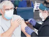  ?? STEVEN SENNE/AP ?? Allan Whitney, of Leominster, Massachuse­tts, receives a COVID-19 shot from nurse Kyle MacLaughli­n Thursday at Gillette Stadium in Foxborough.