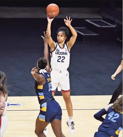  ?? Jessica Hill / Associated Press ?? UConn’s Evina Westbrook (22) shoots over Marquette’s Camryn Taylor during the first half of the Big East tournament final at Mohegan Sun Arena on Monday in Uncasville. The game did not finish in time for this edition. Please visit newstimes.com/sports for game coverage.