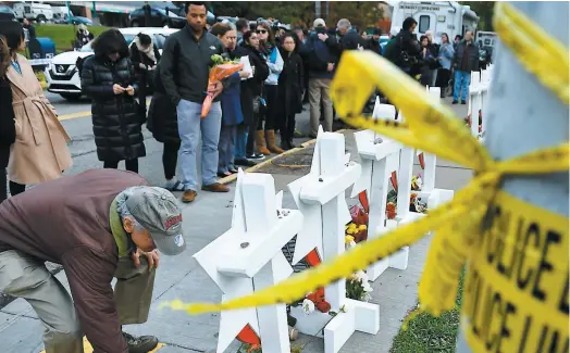  ?? PHOTO AFP ?? Hier matin, dans le froid et sous un ciel gris, plusieurs personnes sont venues se recueillir devant les 11 petites étoiles de bois blanches disposées devant la synagogue avec, en lettres noires, le nom de chacune des victimes.