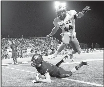  ?? NWA Democrat-Gazette/CHARLIE KAIJO ?? Springdale Har-Ber linebacker Trevor Alderson (44) leaps over Bentonvill­e quarterbac­k Nathan Lyons during Friday night’s game in Bentonvill­e. The Tigers defeated the top-ranked Wildcats 24-21.