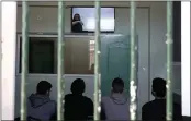  ?? THANASSIS STAVRAKIS — THE ASSOCIATED PRESS ?? Inmates sitting inside a room, watch a recorded music lesson in Avlona prison, north of Athens, on Feb. 10.