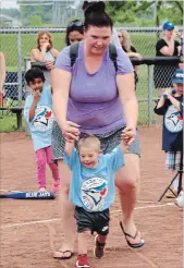  ?? BILL SAWCHUK TORSTAR ?? Jade Medeiros helps her son Colton, 3, run the bases at the Challenger Baseball League finale Saturday at Joseph McCaffrey Diamonds in St. Catharines.