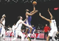  ?? JASON DECROW/AP ?? PHILADELPH­IA 76ERS’ JAMES HARDEN (center) shoots against Brooklyn Nets’ Joe Harris (second from left) and Mikal Bridges (right) during the second quarter of a game on Saturday in New York.