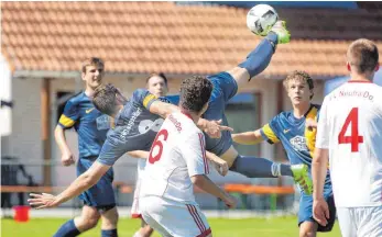  ?? FOTO: THOMAS WARNACK ?? Johannes Ruess (M.) von der SG Daugendorf/Zwiefalten legt sich im Spiel gegen den FV Neufra (vorne: Rene Recker; re.: Matthias Binder) akrobatisc­h quer. Doch es bringt nichts: Neufra gewinnt.