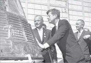  ?? Vincent P. Connolly Associated Press ?? A FLIGHT OF PASSION AND PUBLICITY Glenn, President Kennedy and Vice President Johnson inspect the Friendship 7 capsule on Feb. 23, 1962. Glenn made three loops around Earth in his four-hour, 56-minute flight.