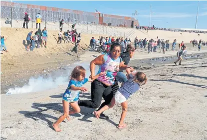  ?? Kim kyung-hoon/reuters ?? Una familia escapa de los gases en la frontera entre México y EE.UU.