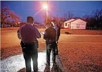  ??  ?? Oklahoma City police officers Joshua Gershon, left, Eric Gengnagel and Billy Robison check a homeowners list in northeast Oklahoma City.