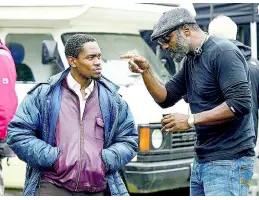  ??  ?? Aml Ameen (left) taking directions from Idris Elba during the filming of ‘Yardie’.