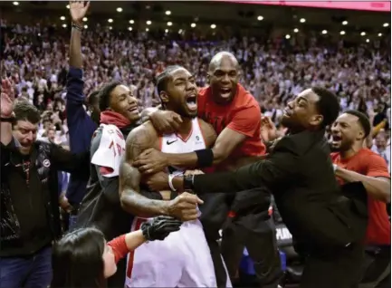  ?? FRANK GUNN - THE ASSOCIATED PRESS ?? Toronto Raptors forward Kawhi Leonard, center, celebrates his game-winning basket as time expired at the end of an Eastern Conference semifinal game against the Philadelph­ia 76ers, in Toronto on Sunday, May 12, 2019. Toronto won 92-90.