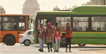  ?? — PRITAM BANDYOPADH­YAY ?? Girls cover themselves with scarves on a hot day at Rajpath in New Delhi on Tuesday.