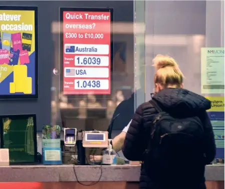  ?? ?? A CUSTOMER AT a currency exchange bureau in Liverpool, UK, on September 27. The UK'S stock and bond markets lost at least $500 billion in combined value in September.