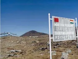  ??  ?? A signboard is seen from the Indian side of the Indo-China border at Bumla. Pic Reuters