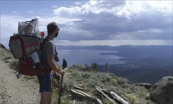  ?? COURTESY KINNEY FAMILY, TNS ?? Matt Kinney of Sacramento looks out over the Tahoe Rim Trail in July 2015 with his 11-month-old son, Thomas. Kinney, his wife and Thomas backpacked the trail for 12 days.