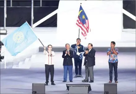  ?? MANAN VATSYAYANA/AFP ?? Representi­ng the next hosts, Philippine Foreign Minister Alan Peter Cayetano (left) waves the SEA Games flag at the Closing Ceremony of the 29th Games at the Bukit Jalil stadium in Kuala Lumpur on Wednesday night.