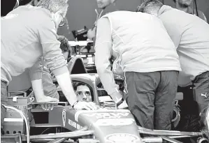  ?? — Gambar AFP ?? PERSIAPAN: Jurutera dan mekanik pasukan Ferrari memeriksa jentera Sainz menjelang perlumbaan F1 GP Australia di Melbourne.