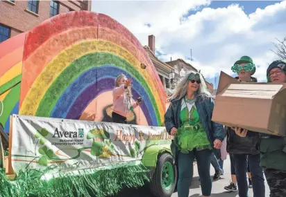  ?? SAMANTHA LAUREY / ARGUS LEADER ?? The Avera Health float passes out St. Patrick’s Day themed items to parade-goers on March 16 along Phillips Avenue in Sioux Falls.