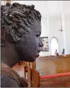  ??  ?? Sculptures of enslaved children are scattered inside the Antioch Baptist Church.