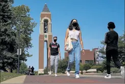  ?? MICHAEL CONROY / AP ?? Masked students walk through the campus of Ball State University in Muncie, Ind., Sept. 10. Colleges across the country are struggling to salvage the fall semester as campus coronaviru­s cases skyrocket and tensions with local health leaders flare.