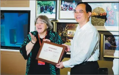  ?? ?? A tree is planted by delegates attending the forum; Elyn MacInnis receives her certificat­e as an Honorary Fuzhou Citizen from Lin Baojin, secretary of