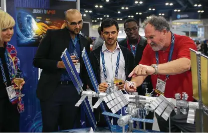  ?? Mark Mulligan photos / Houston Chronicle ?? David Brown, in red, who works at NASA’s Johnson Space Center, talks about the Internatio­nal Space Station with visitors.