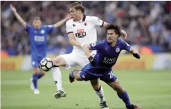  ??  ?? LEICESTER: Watford’s Sebastian Prodl, left, and Leicester City’s Shinji Okazaki, battle for the ball during the English Premier League soccer match Leicester City against Watford at the King Power Stadium. —AP