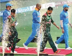  ?? AFP ?? Skippers Rohit Sharma and Mashrafe Mortaza walk the red carpet at the start of the match.