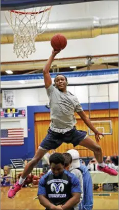  ?? JOHN BLAINE — FOR THE TRENTONIAN ?? Notre Dame’s Cartier Bowman leaps over three of his classmates before dunking the ball during the WBCB Sunshine Foundation Dunk Contest on Thursday night at TCA. Bowman received a perfect score of 50 for the slam.