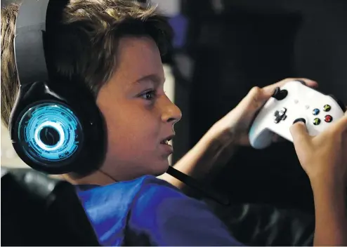  ?? — THE ASSOCIATED PRESS ?? Henry Hailey, 10, plays the online game Fortnite in the early morning hours in the basement of his Chicago home. Getting Henry off screens has been a constant battle, his parents say.