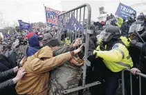  ?? Kent Nishimura / Tribune News Service ?? A pro-trump mob clashes with law enforcemen­t officers at the Capitol on Wednesday during a joint session of Congress.