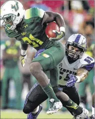  ?? MARK WEBER THE COMMERCIAL APPEAL ?? Memphis defender Leonard Pegues (bottom) harasses South Florida running back Darius Tice (left) at Raymond James Stadium in Tampa, Florida, Friday.