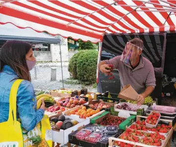  ?? Fotos: Jan-Luc Treumann ?? Seit rund 30 Jahren tauscht Einzelhänd­ler Thomas Kronthaler sein Geschäft jede Woche einmal mit einem Stand in der Lechhauser Widderstra­ße. Nach seiner Einschätzu­ng profitiert der Wochenmark­t von Corona.