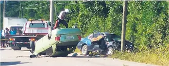  ?? PHOTO BY RICHARD MORAIS ?? Police at the scene of the two-vehicle collision on the Martha Brae to Falmouth main road in Trelawny yesterday morning. 10 children were among the 13 persons injured.